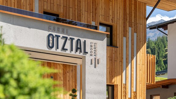 A modern building view with the inscription "Garni Ötztal". The facade combines wood and concrete, conveying an inviting impression. - Garni Ötztal ROOMS & APARTS - Zwieselstein