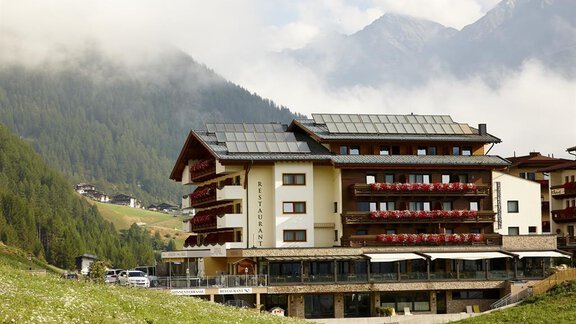 A charming hotel with a modern design, surrounded by mountains and green meadows. The terraces are adorned with flowers and offer a picturesque view. - Alpengasthof Grüner - Sölden