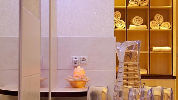 Ein moderner Badbereich mit einem Spiegel, Gläsern auf einem Tisch und einem Regal mit neatly gefalteten Handtüchern. Die Beleuchtung ist sanft und schafft eine einladende Atmosphäre. - Appartement Alpin - Sölden