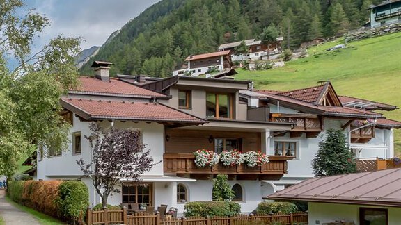 Ein charmantes Gebäude in den Bergen, umgeben von grünen Wiesen und Bäumen. Der gepflegte Weg führt näher zum Hauseingang. - Appartement Cristallo - Sölden