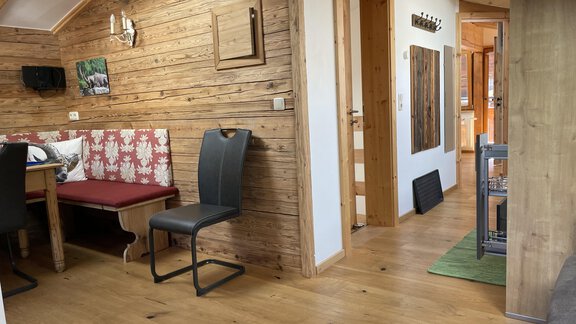 A cozy interior view with a wooden ceiling and a seating area. The floor is made of wood and there are bright walls as well as various pieces of furniture. - HAUS ERIKA apartments - Sölden