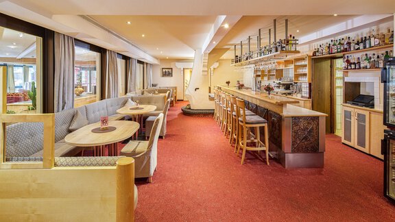 A stylish restaurant with a cozy bar and modern seating options. The large windows provide plenty of light and a pleasant atmosphere. - Hotel Sunny Sölden - Sölden
