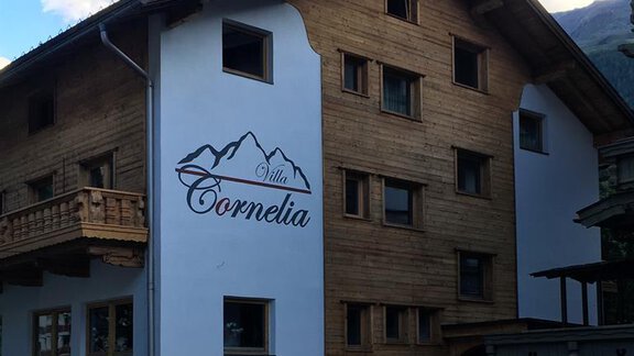Ein modernes Holzgebäude mit der Beschriftung "Villa Cornelia". Es hat mehrere Fenster und einen charmanten alpinen Stil. - Sölden