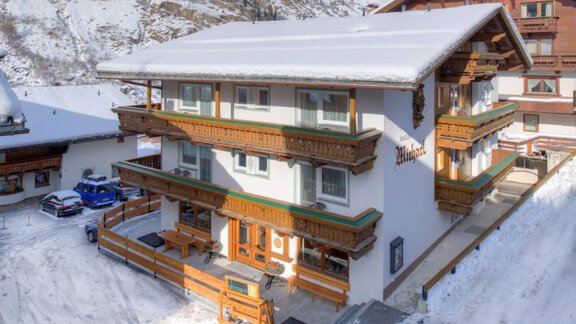 Ein charmantes Chalet im Schnee mit zwei Etagen und Holzverzierungen. Umgeben von Bergen, vermittelt es eine gemütliche Alpenatmosphäre. - Pension Michael - Obergurgl 