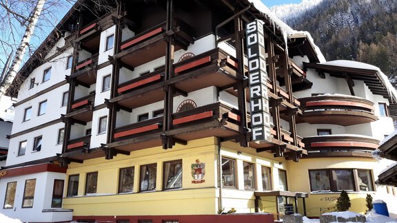 Ein gemütliches Hotel mit dem Namen "Sölderhof" inmitten von Schnee. Die Architektur kombiniert traditionelle alpine Stilelemente mit modernen Annehmlichkeiten. - Hotel Sölderhof - Sölden
