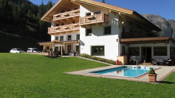 Ein schönes Haus in den Bergen mit einem Pool und großzügiger Wiese. Rundherum ist eine malerische Landschaft. - Pension Waldesruh - Sölden