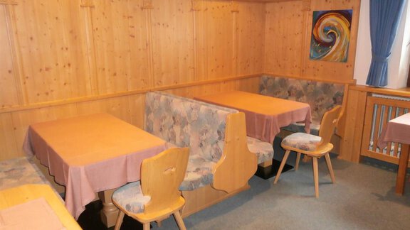 Ein gemütlicher Restaurantbereich mit Holzwänden und Tischdecken. Die Tische sind gut angeordnet, um eine einladende Atmosphäre zu schaffen. - Haus Riml Josef - Zwieselstein