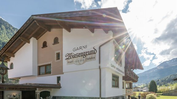 Ein charmantes Gästehaus im alpinen Stil, umgeben von Bergen und Natur. Die Fassade ist hell und einladend, ideal für einen entspannten Aufenthalt. - Apart Wiesengrund - Sölden