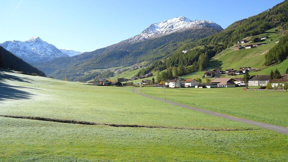 A picturesque landscape with green meadows and snow-capped mountains in the background. The sky is clear and blue, creating a peaceful atmosphere. - Haus Madeleine - Sölden