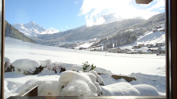 A wintry view with snow-covered hills and mountains. The sun shines over the snowy landscape. - Haus Madeleine - Sölden