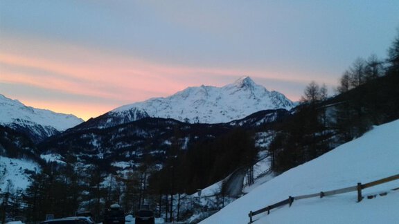 Eine wunderschöne Berglandschaft mit schneebedeckten Hügeln und majestätischen Gipfeln. Der Himmel erstrahlt in sanften Farben bei Sonnenuntergang. - Appt.  Ferienglück - Sölden