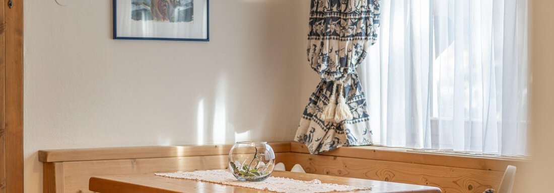 Ein gemütlicher Essbereich mit einem Holztisch und Bänken. Große Fenster lassen viel Tageslicht hereINKOMMEN. - Ferienwohnung Alt Poschach - Obergurgl 