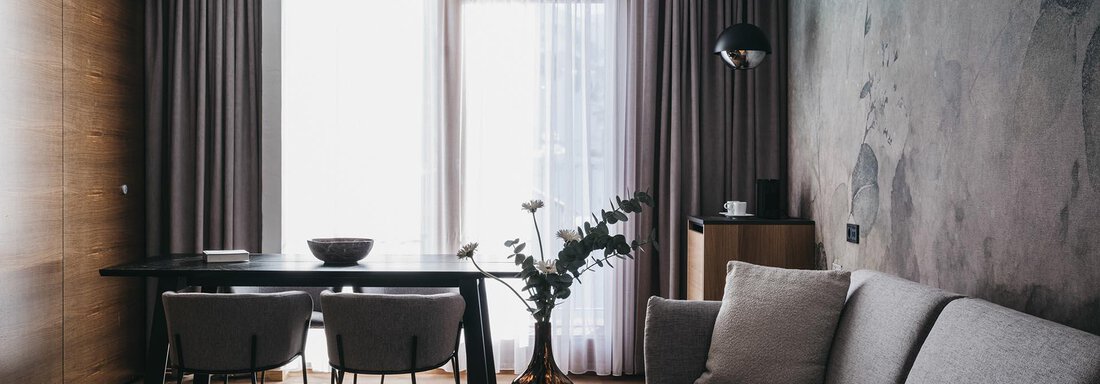 VAYACrystal-66 A modern living room with a comfortable sofa and an elegant table. Large windows provide plenty of natural light and a pleasant atmosphere. - The Crystal VAYA Unique - Obergurgl