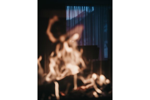 A fire flickers against a dark background with curtains. The light creates a cozy and warm atmosphere. - The Crystal VAYA Unique - Obergurgl 