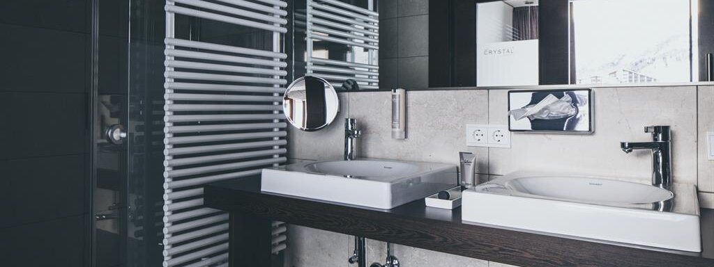 An elegant bathroom with modern sinks and stylish furnishings. The space is bright and well-structured, with a large window for natural light. - The Crystal VAYA Unique - Obergurgl 