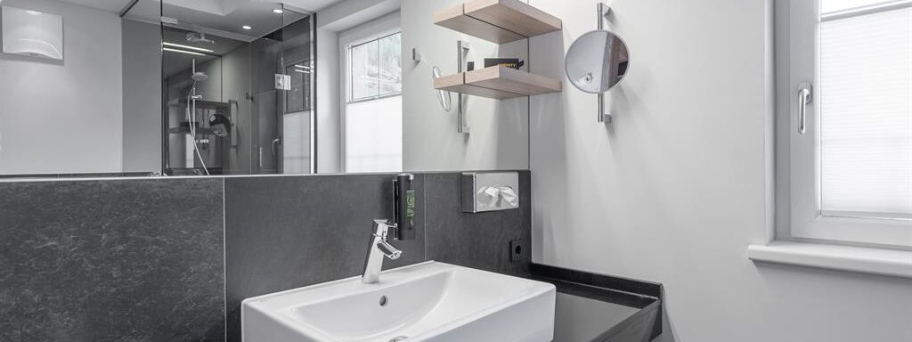Ein modernes Badezimmer mit einem stilvollen Waschbecken und einer minimalistischen Ausstattung. Große Fenster sorgen für viel Tageslicht. - AlpenParks The Secret Sölden - Sölden