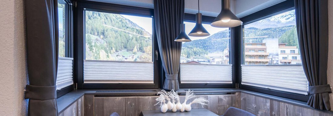 Ein eleganter Essbereich mit großen Fenstern und Blick auf die Berge. Der Tisch ist modern und die Stühle sind gemütlich. - Apart Reinstadler - Sölden