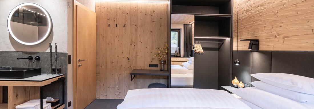 Ein modernes Hotelzimmer mit zwei Einzelbetten, Holzverkleidung und sanftem Licht. Das Zimmer verfügt über eine elegante Badzeile und große Fenster. - Apart Reinstadler - Sölden