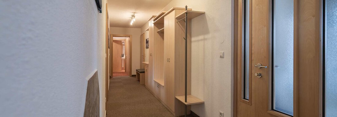 Ein heller Flur mit minimalistischer Einrichtung. An der Wand befinden sich Garderoben und Türen zu anderen Räumen. - Apart Reinstadler - Sölden