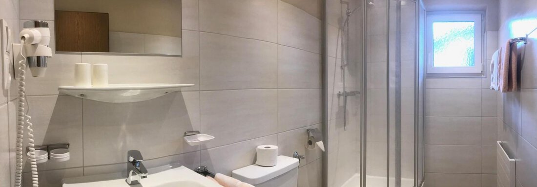 Ein modernes Badezimmer mit einer Duschkabine und einem Waschbecken. Helle Fliesen und sanfte Beleuchtung sorgen für eine angenehme Atmosphäre. - Appartement Viertler - Sölden