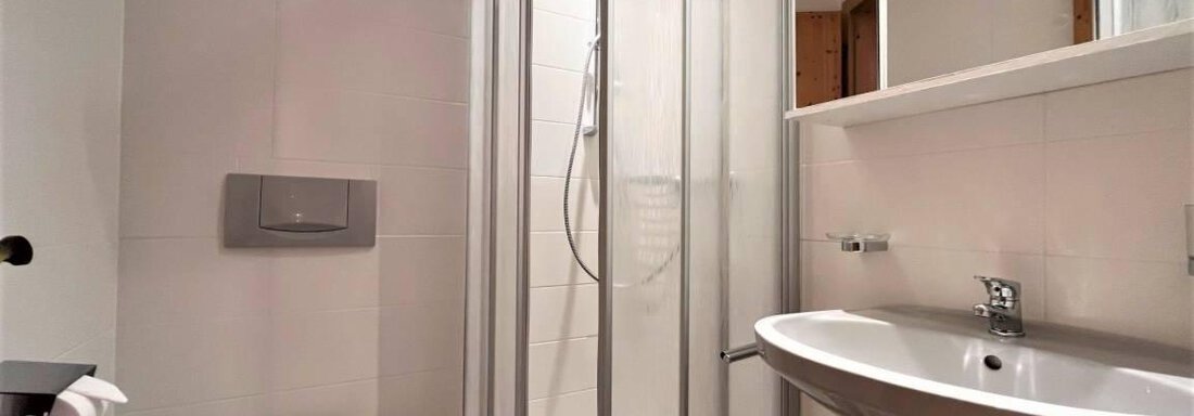 Ein modernes Badezimmer mit einer Dusche aus Glas und einem eleganten Waschbecken. Die Wände sind in neutralen Farben gehalten, und der Raum wirkt hell und freundlich. - Garni Nadine - Sölden