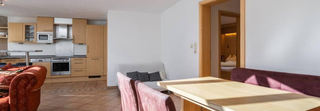 Eine helle und moderne Wohnung mit einem Essbereich und einer offenen Küche. Große Fenster sorgen für viel Tageslicht. - Garni Nadine - Sölden