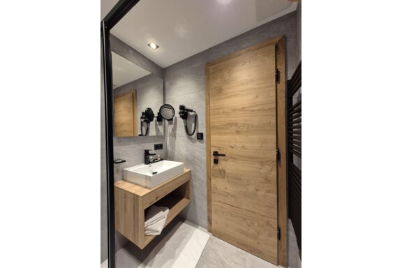 Ein modernes Badezimmer mit einer Dusche. Der Raum hat helle Fliesen und einen großen Spiegel. - Gästehaus Maier - Sölden