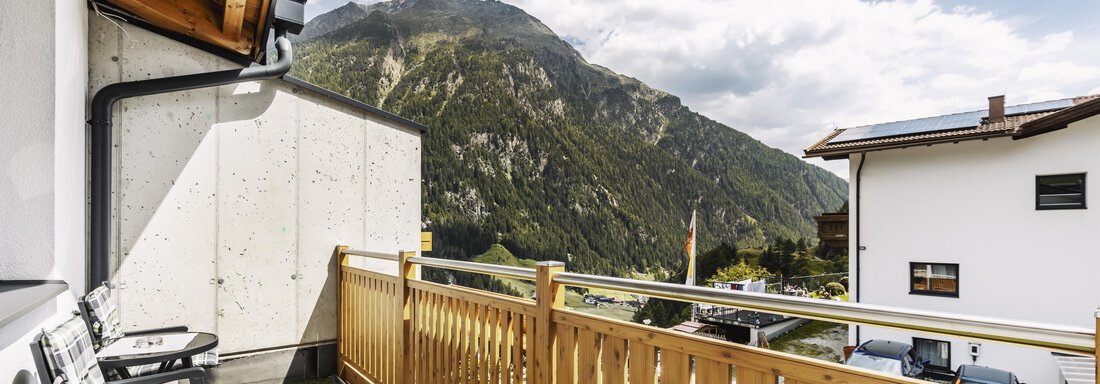 Ein Balkon mit Holzgeländer und Blick auf die Berge. Die Wolken sind teilweise sichtbar und die Atmosphäre ist ruhig. - Gasthof Granstein - Sölden