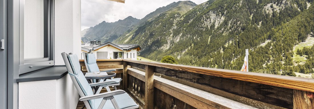 Ein Balkon mit zwei Liegestühlen und Blick auf die hohen Berge. Die Atmosphäre ist ruhig und einladend. - Gasthof Granstein - Sölden
