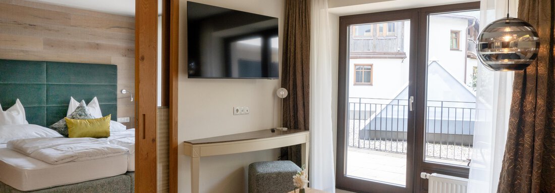 _DSC4695 copy A modern room with a large bed and a television.
Large windows let in a lot of daylight and offer a view of a balcony. - Glanz & Glory Hotel - Sölden