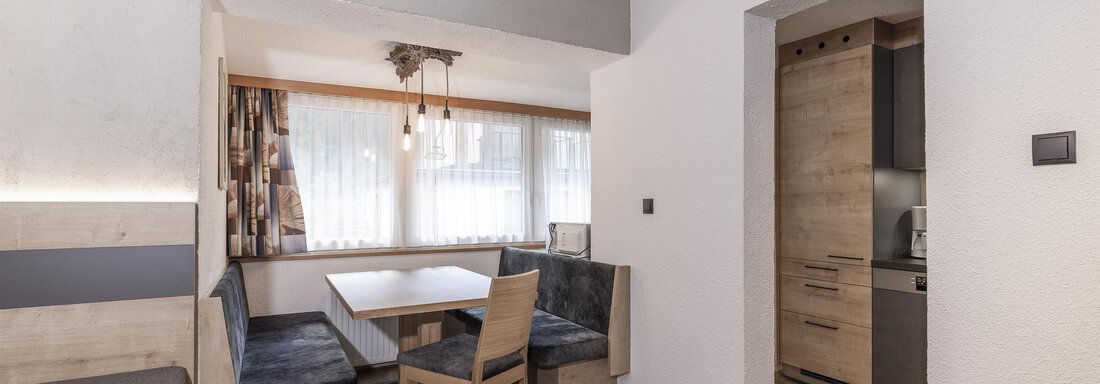 Ein modernes Apartment mit einem gemütlichen Essbereich und einer Küchenzeile. Helle Wände und Holzfußboden schaffen eine einladende Atmosphäre. - Haus Manfred - Sölden