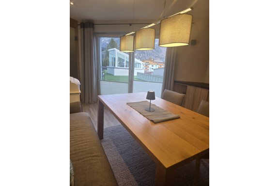 Ein moderner Essbereich mit einem Holz-Tisch und gemütlichen Stühlen. Große Fenster bieten einen Blick auf die Außenlandschaft. - Hotelappart Peter - Sölden