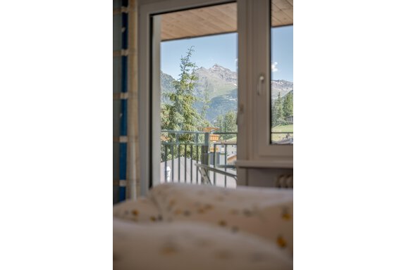 A beautiful view through a window of mountains and trees. The sun is shining and the sky is clear. - Pension Charly - Sölden