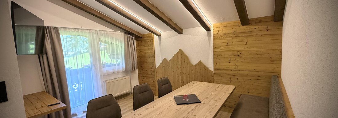 Ein moderner Essbereich mit einem großen Holztisch und bequemen Stühlen. Natürliche Holzverkleidung und große Fenster sorgen für ein helles, einladendes Ambiente. - Pension "Zur alten Mühle" - Sölden