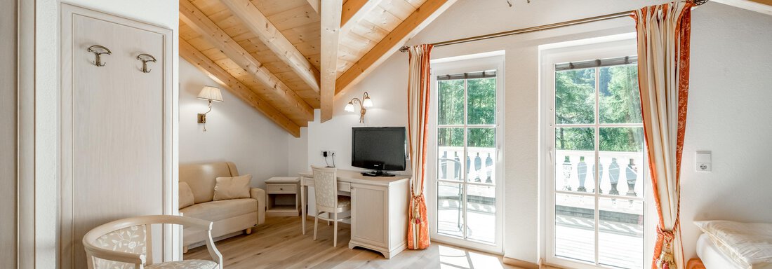 Eine helle und einladende Dachgeschosswohnung mit Holzdecken. Sie verfügt über ein Wohnzimmer, einen Fernseher und große Fenster mit Blick auf die Natur. - Villa Castelbell - Sölden
