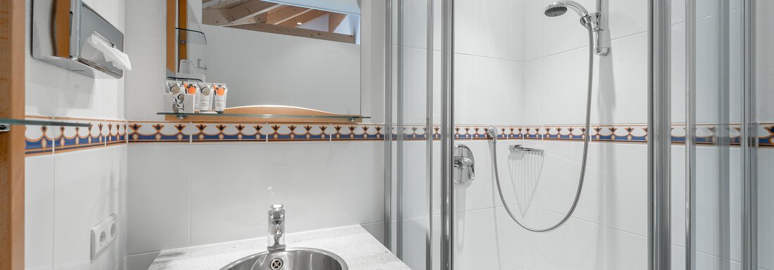 Ein modernes Badezimmer mit einer Dusche und einem Waschbecken. Die Wände sind hell und der Raum wirkt sauber und einladend. - Villa Castelbell - Sölden