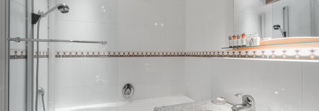 Ein modernes Badezimmer mit einer Badewanne und einer Dusche. Der Waschbereich ist stilvoll und hell gestaltet. - Villa Castelbell - Sölden