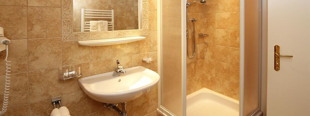 Ein modernes Badezimmer mit Fliesen in neutralen Tönen. Es enthält eine Dusche, ein Waschbecken und einen Spiegel. - Waldele - Sölden