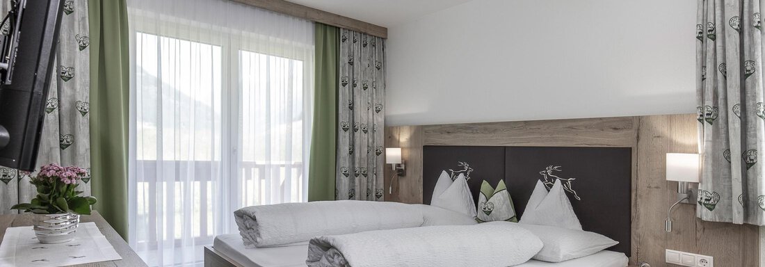 Ein modernes Zimmer mit einem Doppelbett und einem gemütlichen Holzdesign. Große Fenster lassen viel Licht hinein und bieten einen schönen Blick nach draußen. - Zenz´n Hof - Sölden