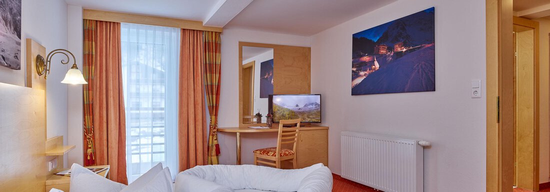 Ein gemütliches Hotelzimmer mit zwei Betten und einem Schreibtisch. Helle Farben und ein Fenster sorgen für eine freundliche Atmosphäre. - Hotel Vent - Vent