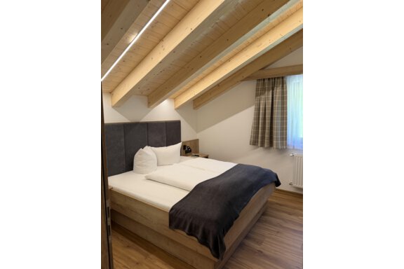 A modern bedroom with a wood ceiling and a cozy bed. Large windows let in plenty of daylight. - Mein Weisskugel - Vent