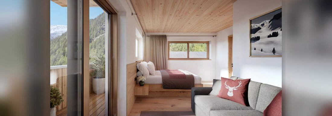 Ein modernes Zimmer mit Holzwänden und einem großen Fenster. Es gibt ein gemütliches Sofa und zwei Einzelbetten. - Chalet s’Tyrolia - Zwieselstein
