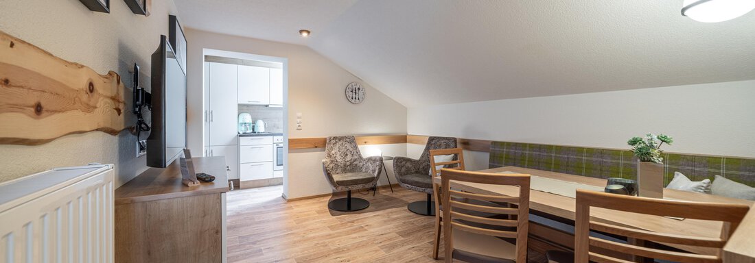 Ein heller, einladender Wohnraum mit einem Tisch und Stühlen. Die Einrichtung ist modern und gemütlich, ideal für entspannte Stunden. - Garni Ötztal ROOMS & APARTS - Zwieselstein